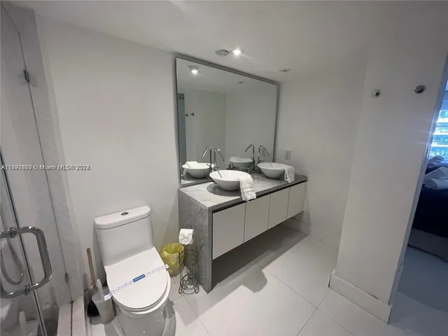 a bathroom with a double vanity sink mirror and toilet