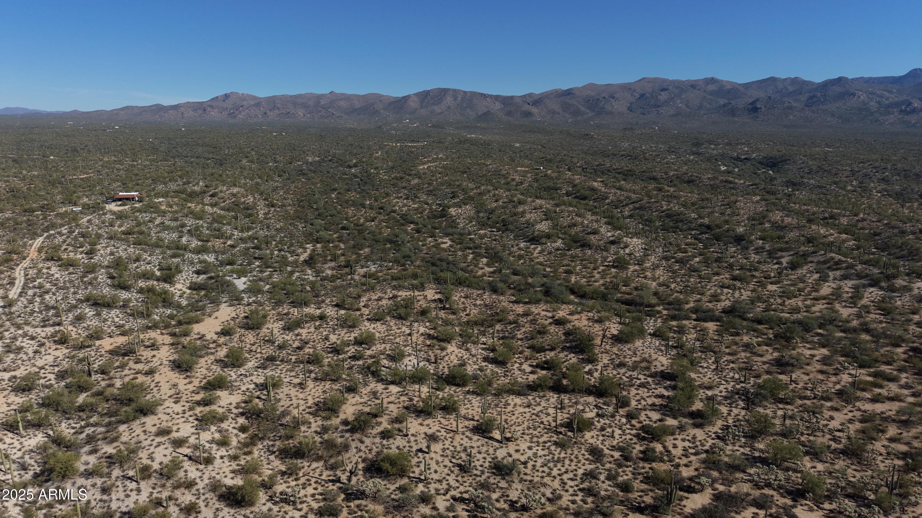 a view of a lush green field with mountains in the background