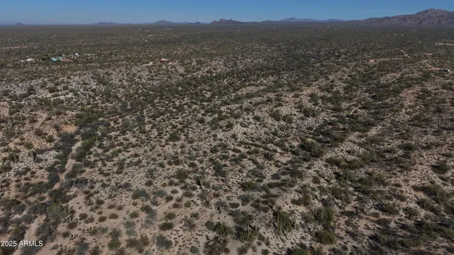 an aerial view of house with yard and mountain view in back