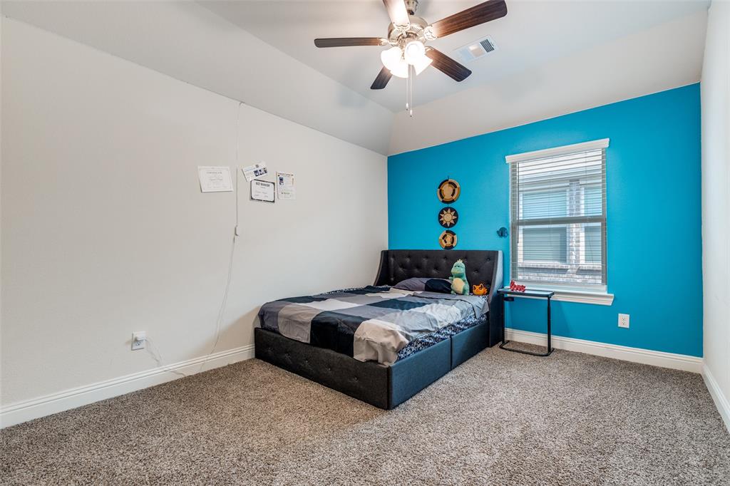 7636 Cherry Blossom Lane Little Elm, TX 76227 - Photo 18 of 31 a bedroom with a bed and a chandelier