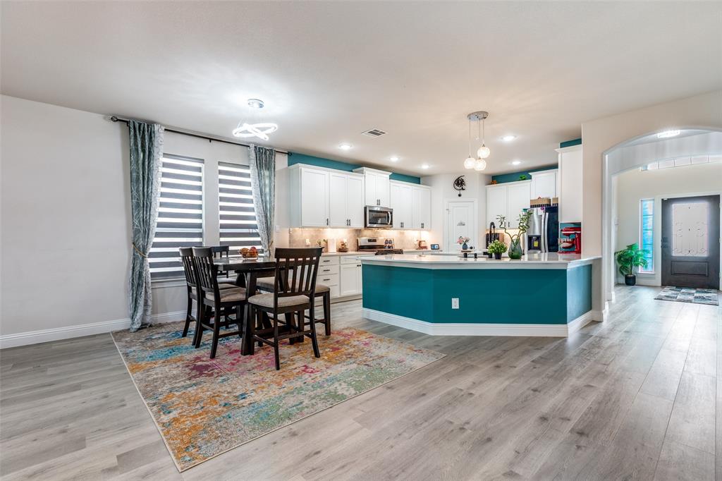 7636 Cherry Blossom Lane Little Elm, TX 76227 - Photo 4 of 31 a view of a dining room with furniture and wooden floor