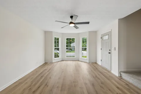 a kitchen with stainless steel appliances a stove top oven a sink dishwasher and a microwave with wooden floor