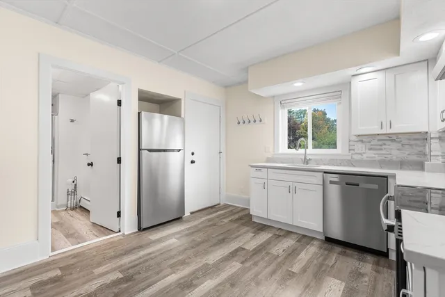 a kitchen with a refrigerator sink and cabinets
