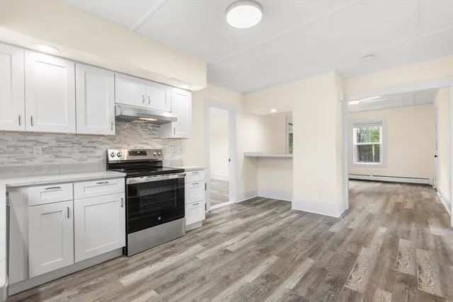 a kitchen with a refrigerator and white cabinets