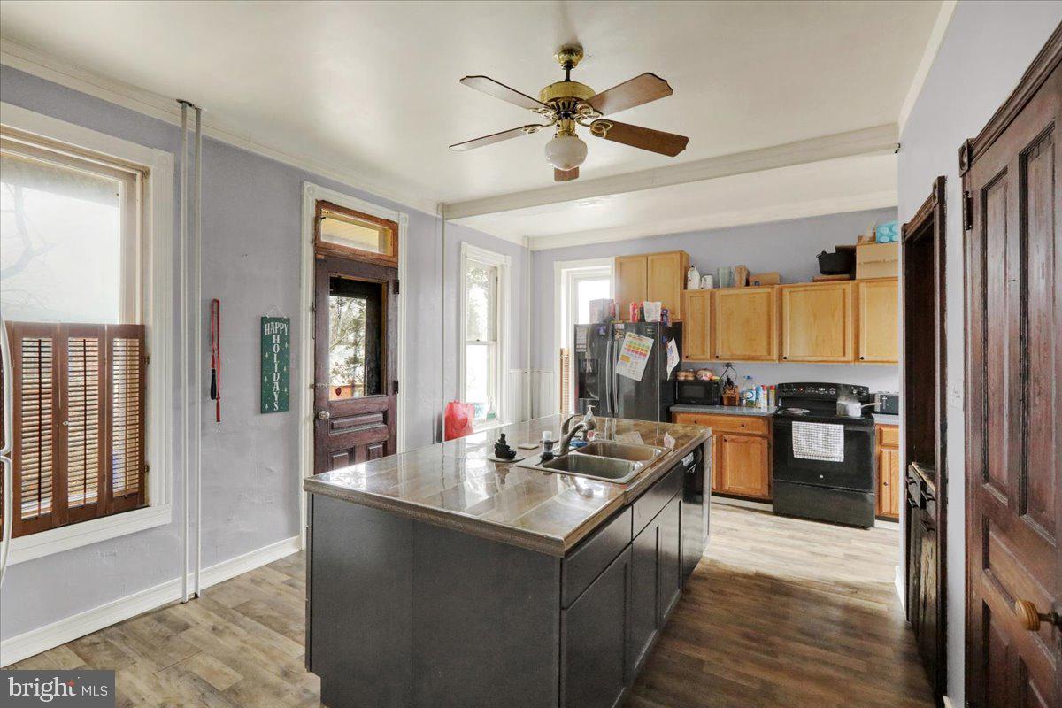 434 Main Street Oley, PA 19547 - Photo 12 of 30 a kitchen with stainless steel appliances kitchen island granite countertop a refrigerator a sink dishwasher a dining table and chairs with wooden floor