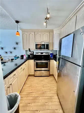 a kitchen with stainless steel appliances a stove sink and microwave