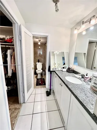 a large white kitchen with a sink and a refrigerator
