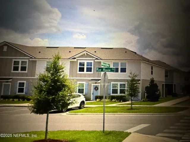 a front view of a house with a garden and plants