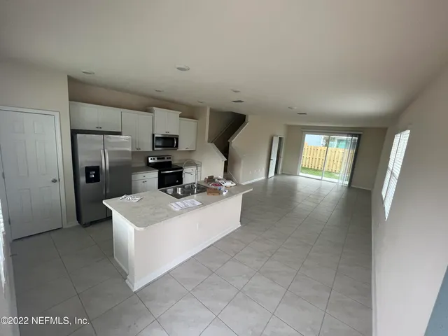 a view of kitchen with sink microwave and refrigerator
