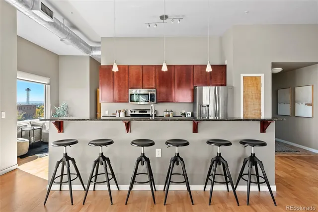 a kitchen with stainless steel appliances a table chairs sink and cabinets