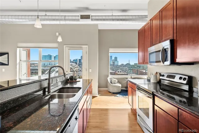 a kitchen with stainless steel appliances granite countertop a sink stove and refrigerator