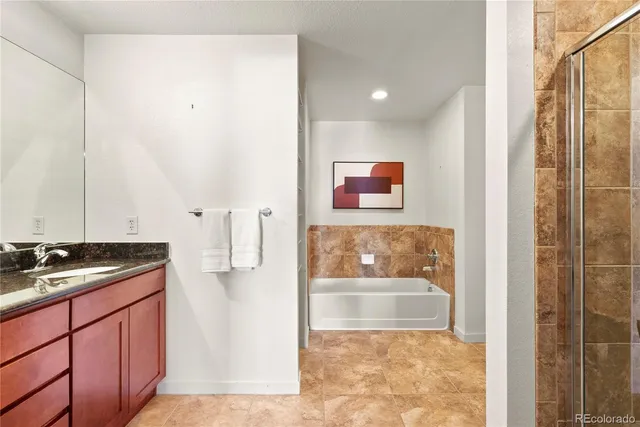 a bathroom with a granite countertop sink a mirror and shower