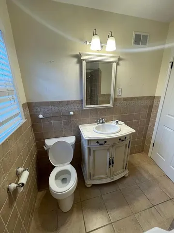 a bathroom with a toilet sink and mirror