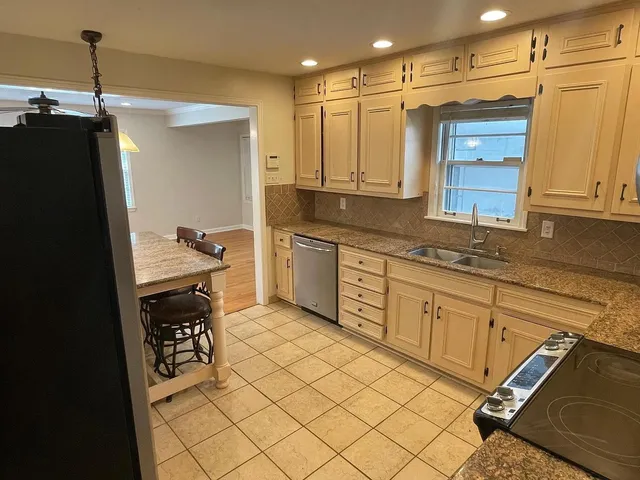 a kitchen with a sink refrigerator and cabinets