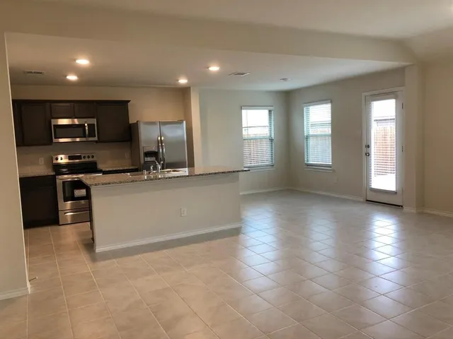 a kitchen with stainless steel appliances granite countertop a stove a sink and a microwave