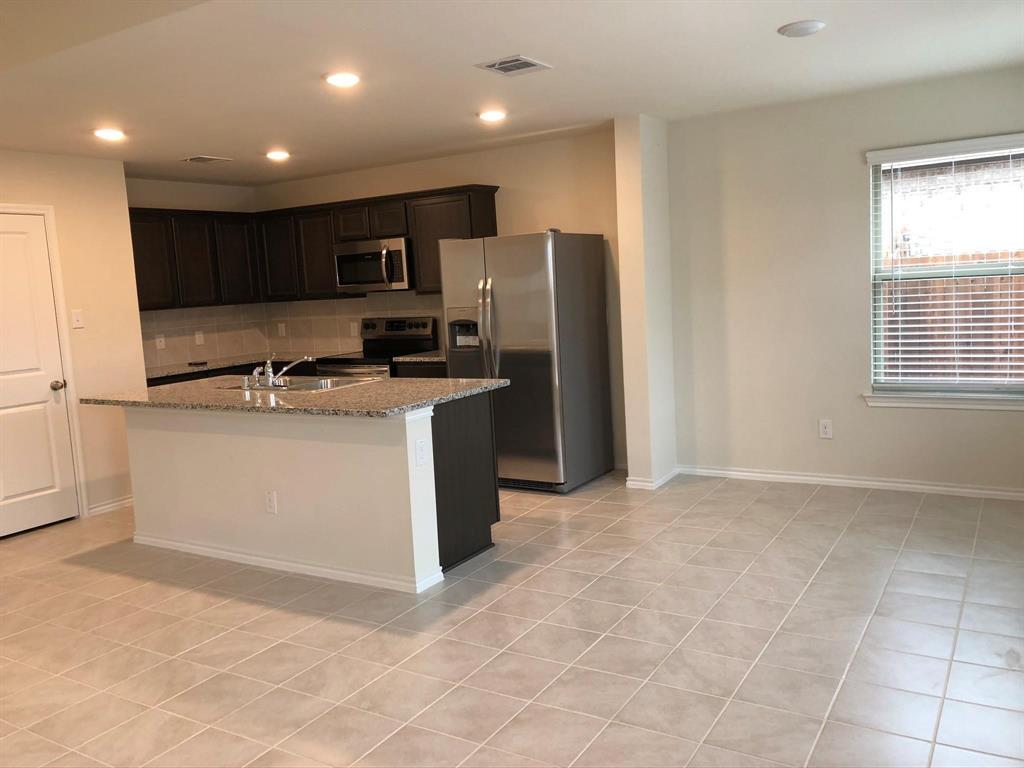 604 Rustic Meadows Trail Princeton, TX 75407 - Photo 13 of 15 a kitchen with stainless steel appliances granite countertop a sink stove and refrigerator