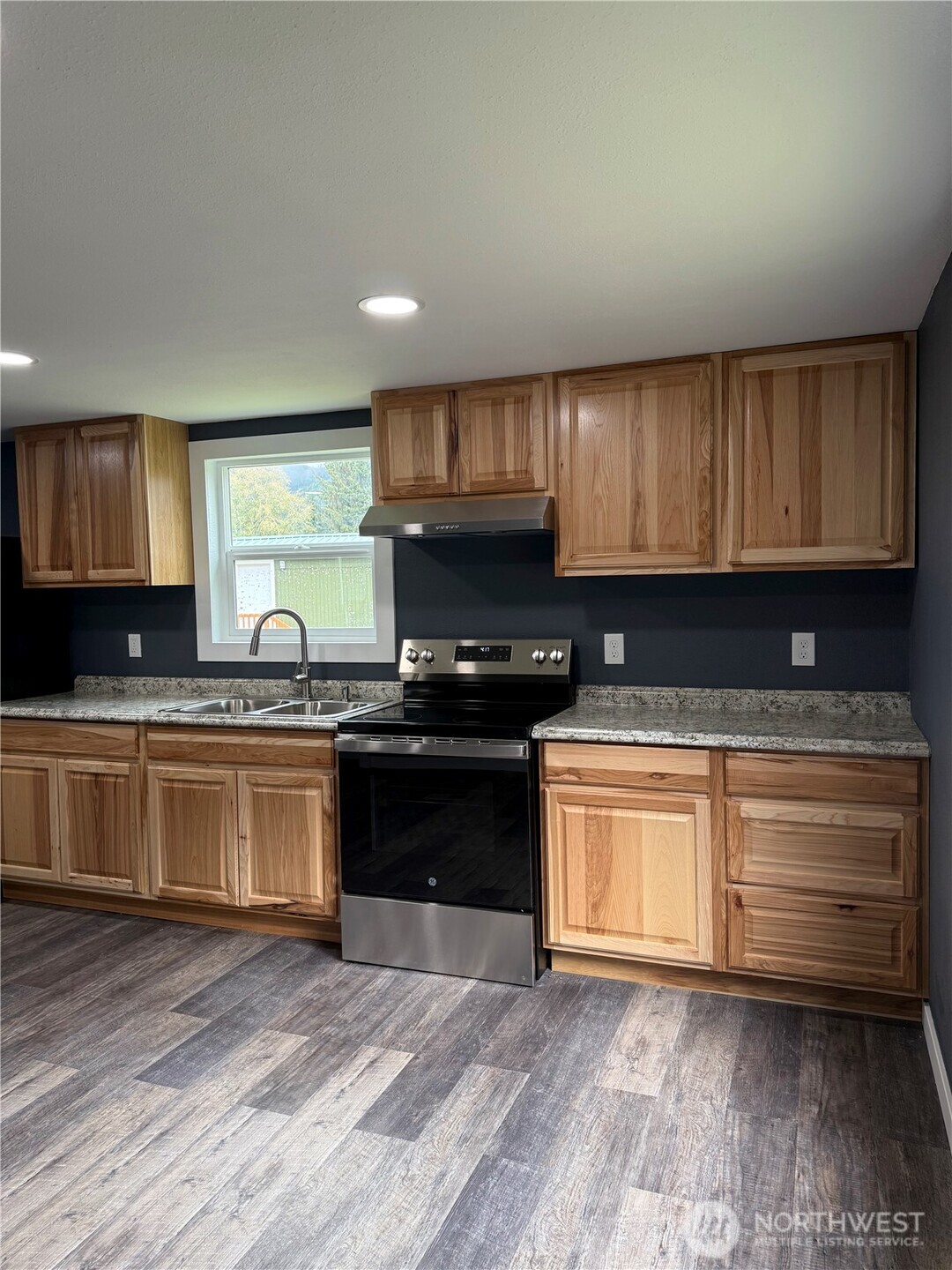 2610 Calawah Way, Unit 47 Forks, WA 98331 - Photo 15 of 17 a kitchen with granite countertop wooden cabinets and a stove top oven
