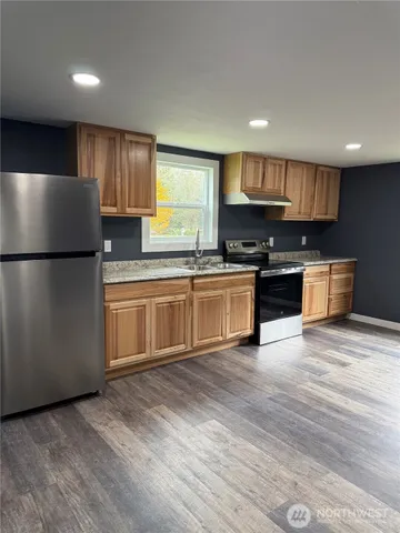 a kitchen with stainless steel appliances granite countertop a refrigerator sink and cabinets