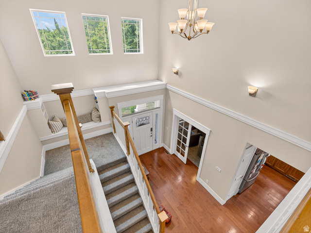 557 Craftsman Way Midway, UT 84049 - Photo 31 of 59 Two-story foyer featuring hardwood flooring, a multi-tiered chandelier, and three upper-level windows