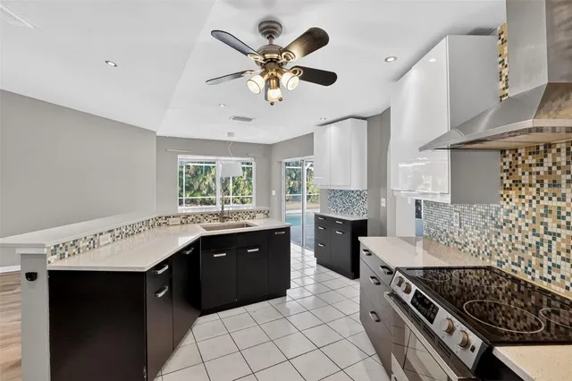 a kitchen with stainless steel appliances granite countertop a stove a sink a refrigerator and a stove