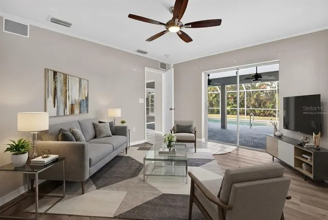 a living room with furniture a flat screen tv and a large window
