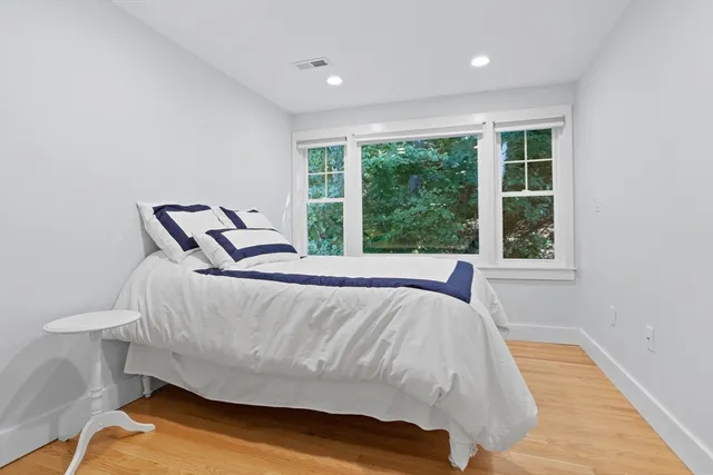 a bed sitting in a spacious bedroom next to a window
