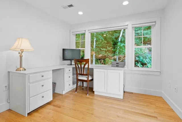 a view of a workspace with furniture and a window