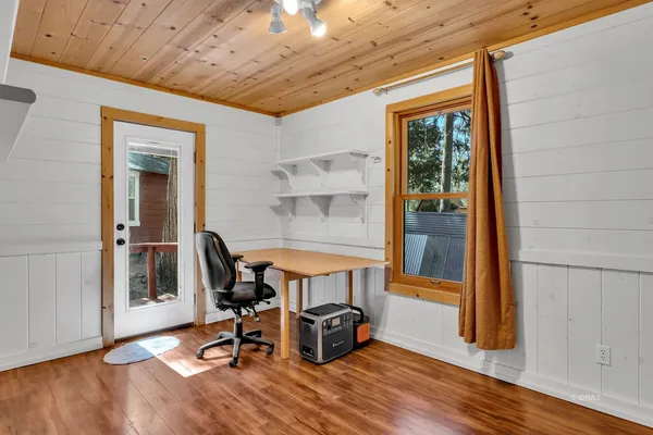 a view of a room with wooden floor and furniture