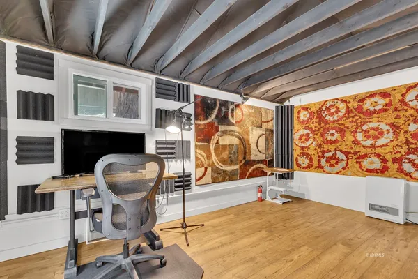 a view of a livingroom with wooden floor and furniture