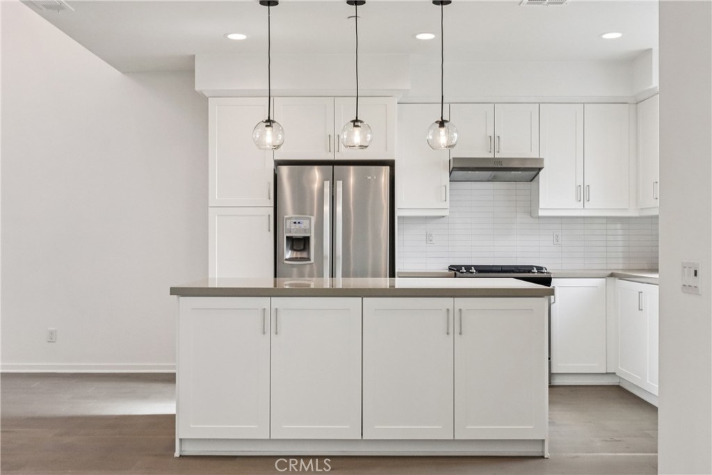 170 Fable Irvine, CA 92618 - Photo 11 of 27 a kitchen with stainless steel appliances granite countertop a sink a stove and white cabinets