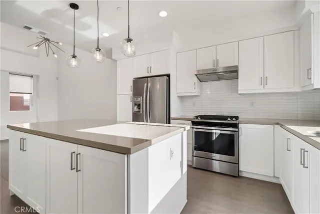 a kitchen that has a sink a stove and a refrigerator