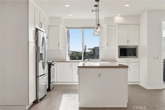 a kitchen with stainless steel appliances a refrigerator and a stove top oven
