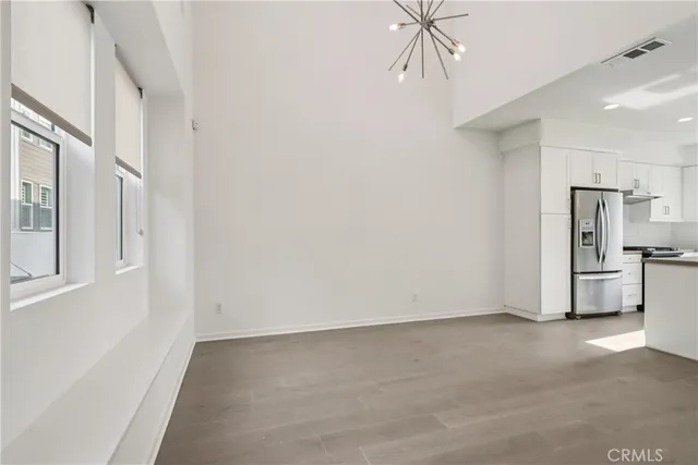 a view of a kitchen with refrigerator and a stove