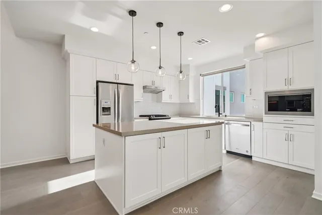a kitchen with white cabinets and white appliances
