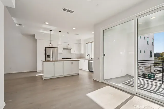 a large white kitchen with a refrigerator a stove a sink cabinets and a counter top space