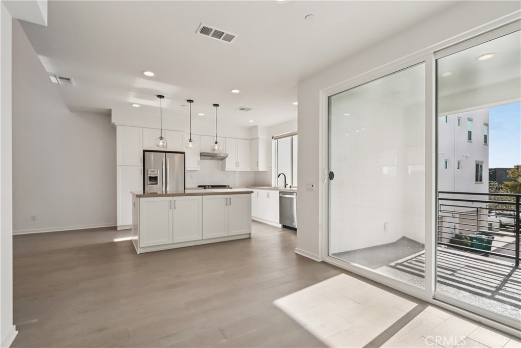 170 Fable Irvine, CA 92618 - Photo 3 of 27 a large white kitchen with a refrigerator a stove a sink cabinets and a counter top space