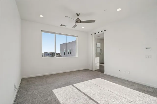 an empty room with fan and windows