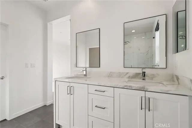 a bathroom with a granite countertop sink double and mirror