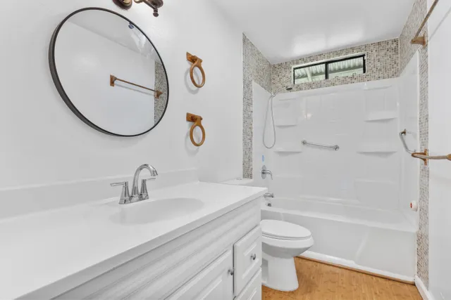 a bathroom with a sink a toilet and a mirror