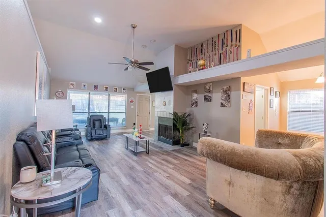 a living room with furniture kitchen view and a large window