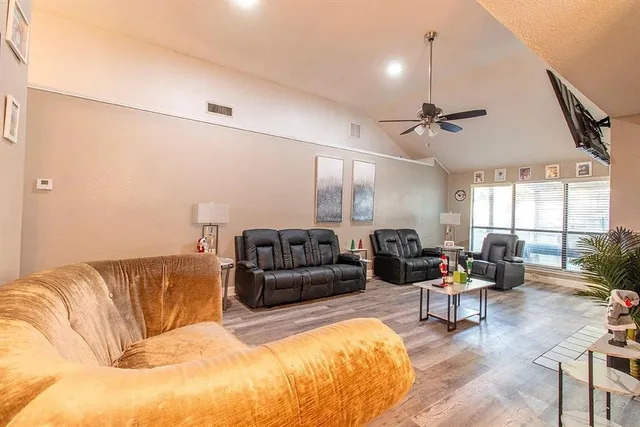 a living room with furniture ceiling fan and a rug
