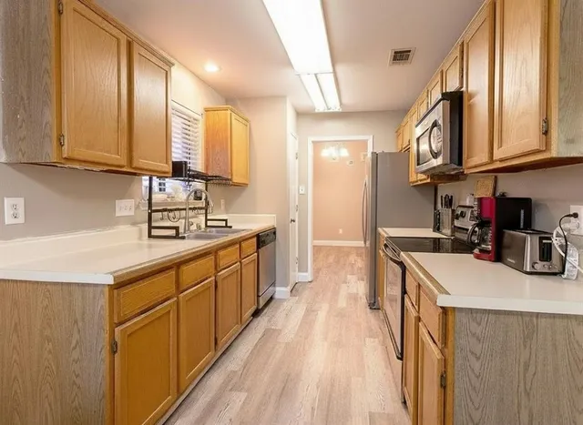 a kitchen with stainless steel appliances granite countertop a sink stove and cabinets