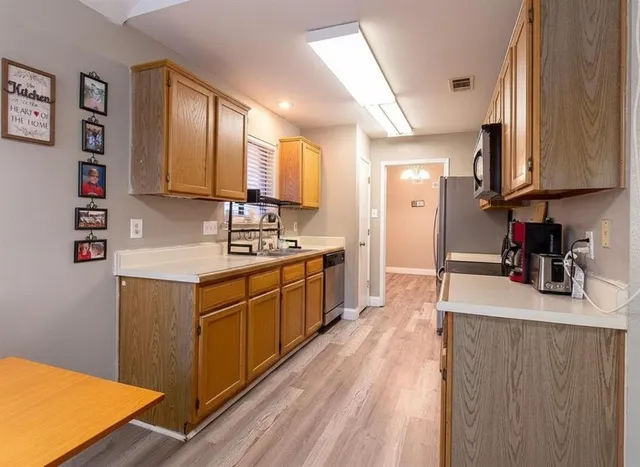 a kitchen with kitchen island granite countertop a sink cabinets and wooden floor