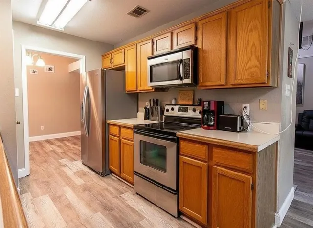 a kitchen with stainless steel appliances granite countertop a stove a sink and a microwave
