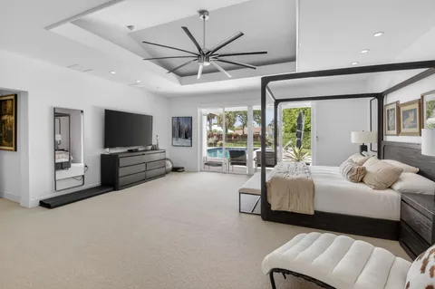 a bedroom with a bed window and a flat screen tv