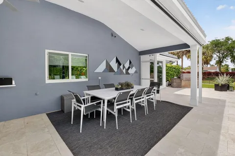 a dining room with furniture a rug and a large window