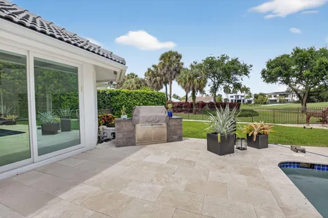 a view of a patio with a table and chairs next to a yard