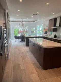 a large open kitchen with stainless steel appliances granite countertop a lot of counter space and wooden floors