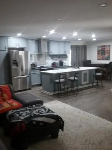 a kitchen with stainless steel appliances granite countertop a sink a stove a refrigerator and a oven