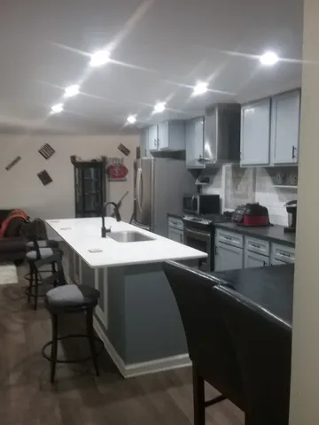 a kitchen with a sink and chairs